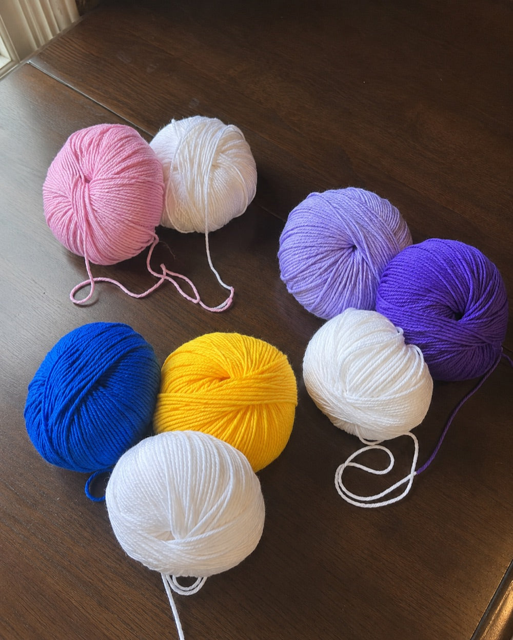 Balls of yarn in pink, white, blue, yellow and purple